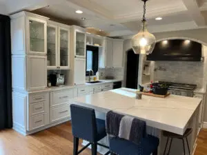 Bright modern kitchen with white cabinets and marble island completed during a kitchen renovation in Zeeland MI