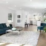 Bright living room with white walls and hardwood floors, showing how professional painters protect furniture and floors during interior projects
