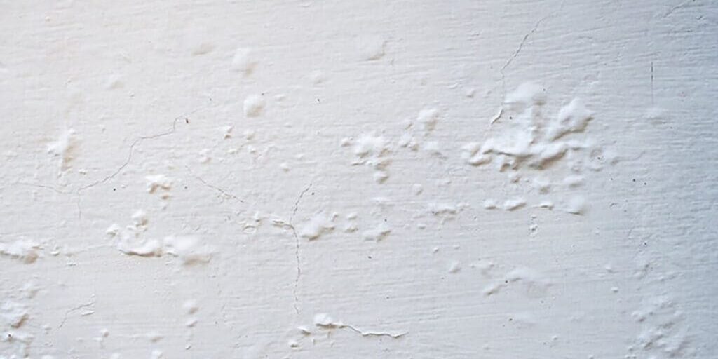 how humid weather affects interior paint causing bubbling and surface defects on an interior wall