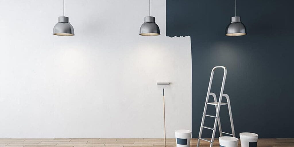 Interior painting projects that refresh your home, showing a modern accent wall being painted with ladders and paint supplies in place